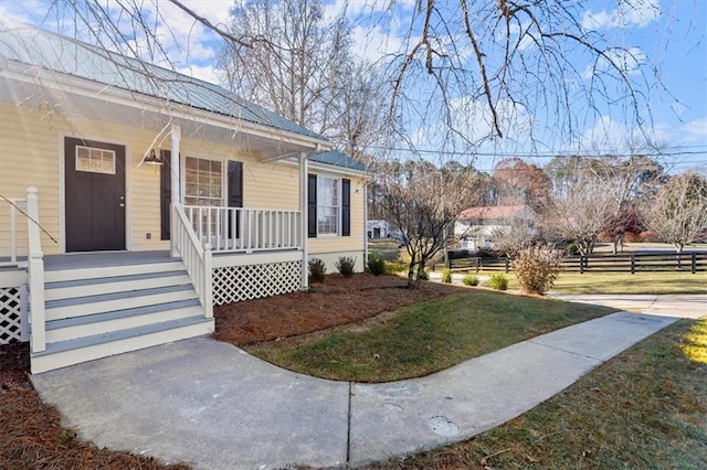 view of side of property featuring a porch and a lawn