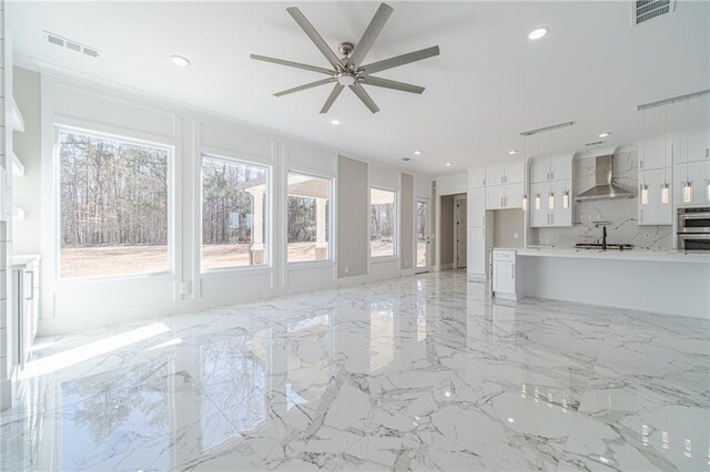 unfurnished living room with ceiling fan and sink