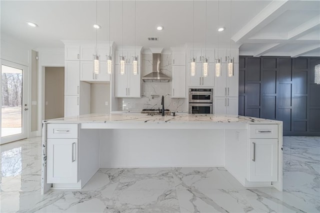 kitchen featuring marble finish floor, wall chimney exhaust hood, white cabinetry, and backsplash