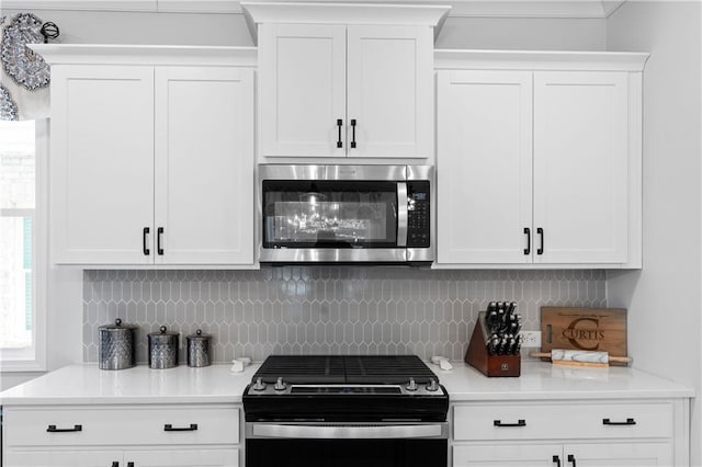 kitchen featuring white cabinetry, tasteful backsplash, and black gas range oven