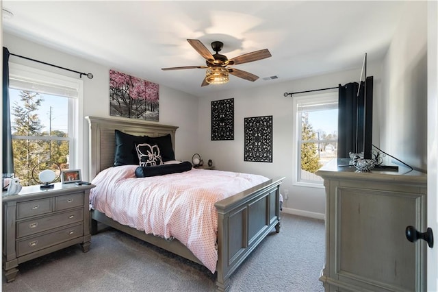 carpeted bedroom with ceiling fan and multiple windows