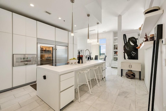 285 Centennial Olympic Park Dr NW Unit Ph2-7, Atlanta, GA 30313 - kitchen with modern cabinets, white cabinetry, a breakfast bar, a center island with sink, and recessed lighting