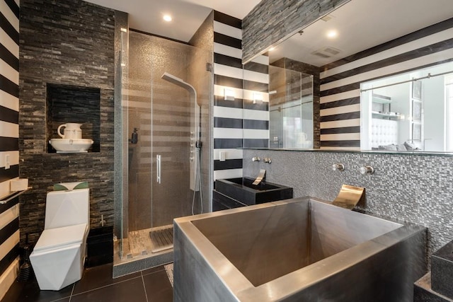 285 Centennial Olympic Park Dr NW Unit Ph2-7, Atlanta, GA 30313 - bathroom with tile patterned floors, a stall shower, tile walls, toilet, and a sink