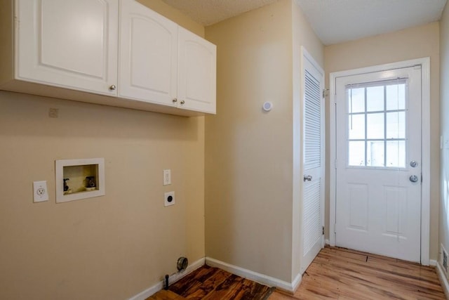 laundry room featuring hookup for an electric dryer, washer hookup, cabinets, and light hardwood / wood-style flooring