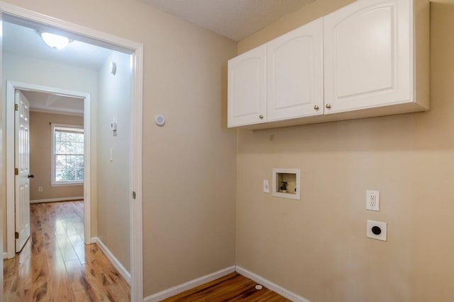 laundry area featuring electric dryer hookup, light hardwood / wood-style floors, cabinets, and hookup for a washing machine