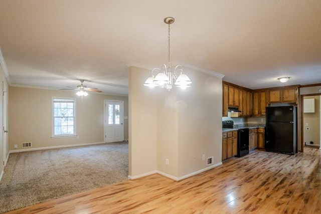 kitchen featuring light hardwood / wood-style flooring, black appliances, decorative light fixtures, and ornamental molding