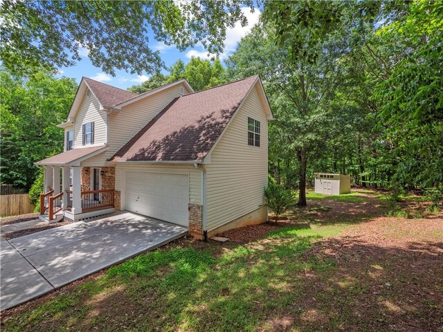 6333 Horizon Dr, Flowery Branch, GA 30542 - view of front of home featuring an attached garage, roof with shingles, driveway, a shed, and stone siding