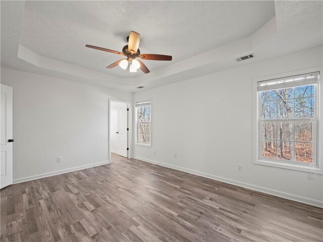 6333 Horizon Dr, Flowery Branch, GA 30542 - unfurnished bedroom featuring a raised ceiling, wood finished floors, baseboards, and a ceiling fan