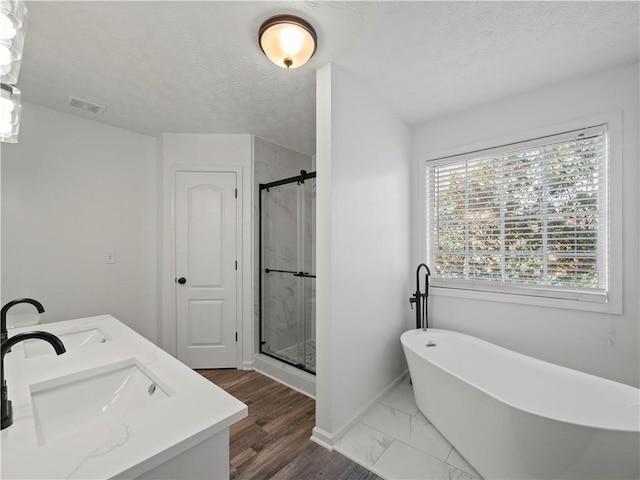 6333 Horizon Dr, Flowery Branch, GA 30542 - bathroom featuring a shower stall, baseboards, a freestanding bath, a textured ceiling, and marble look tile flooring