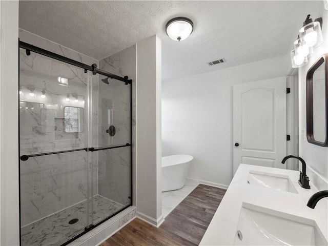 6333 Horizon Dr, Flowery Branch, GA 30542 - full bath featuring a freestanding bath, a stall shower, a textured ceiling, baseboards, and double vanity