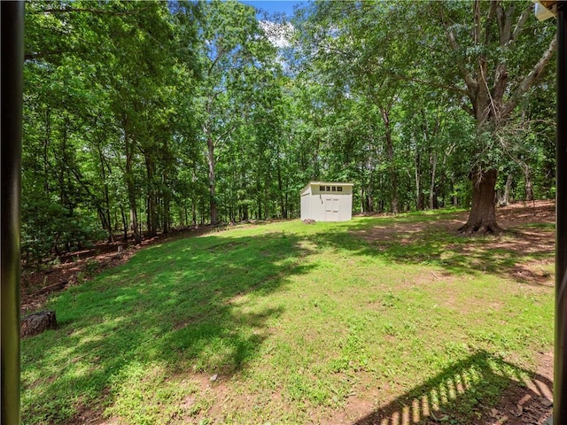 6333 Horizon Dr, Flowery Branch, GA 30542 - view of grassy yard with a storage unit, an outdoor structure, and a view of trees