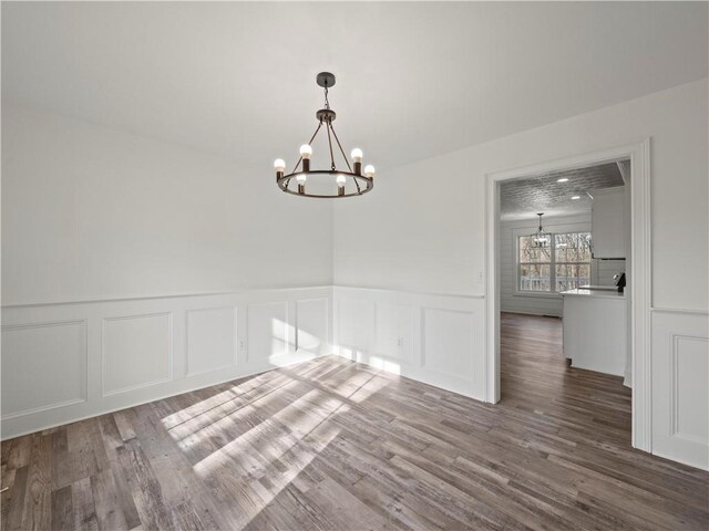 6333 Horizon Dr, Flowery Branch, GA 30542 - unfurnished room featuring a chandelier, a decorative wall, wood finished floors, and wainscoting