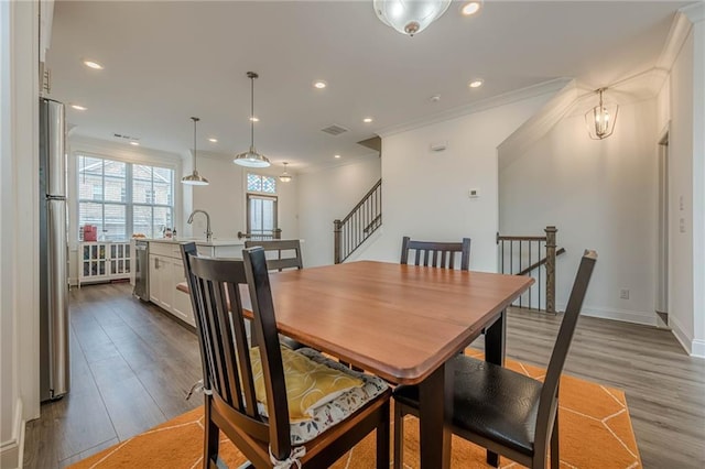 dining room with recessed lighting, wood finished floors, and ornamental molding
