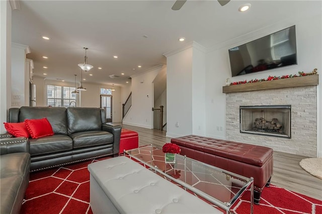 living area featuring recessed lighting, a fireplace, crown molding, and wood finished floors