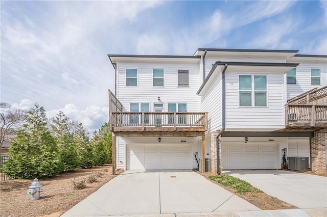 multi unit property with cooling unit, driveway, and a garage