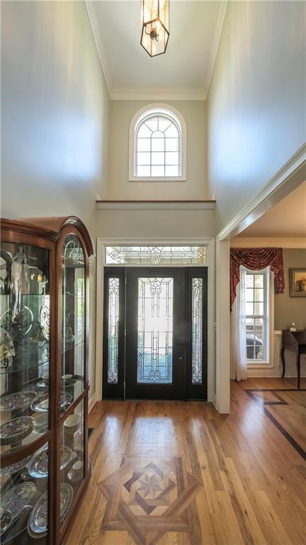 9742 Fallview Ct, Villa Rica, GA 30180 - entrance foyer with crown molding, plenty of natural light, a towering ceiling, and wood finished floors