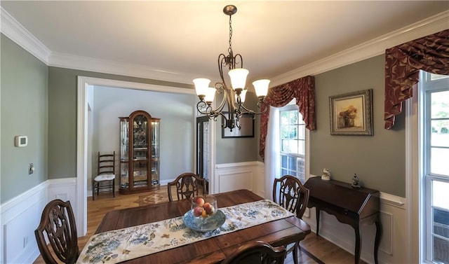 9742 Fallview Ct, Villa Rica, GA 30180 - dining space featuring a wainscoted wall, a chandelier, crown molding, plenty of natural light, and wood finished floors