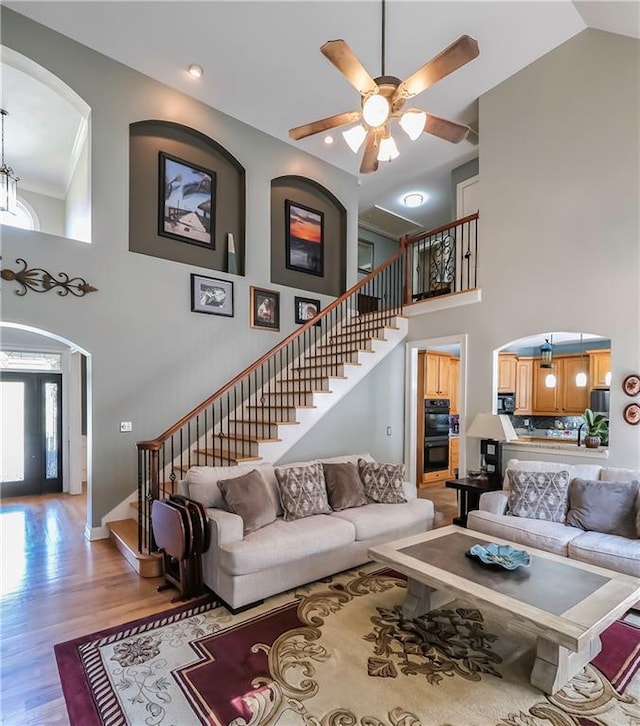 9742 Fallview Ct, Villa Rica, GA 30180 - living area featuring arched walkways, stairs, a high ceiling, light wood-style floors, and a ceiling fan