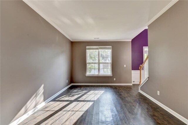 spare room featuring crown molding and dark hardwood / wood-style floors