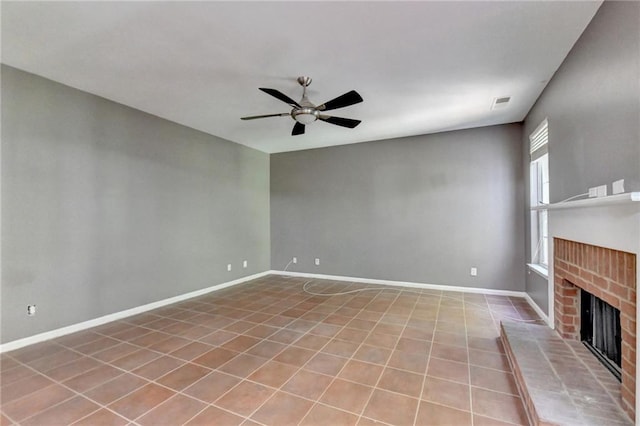 unfurnished living room featuring a fireplace, ceiling fan, and tile patterned floors