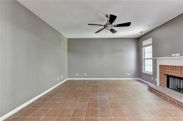 unfurnished living room featuring ceiling fan, tile patterned flooring, and a fireplace