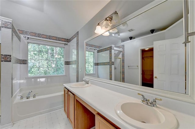 full bathroom with a stall shower, vaulted ceiling, a garden tub, and a sink