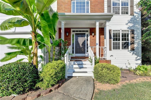 doorway to property featuring brick siding