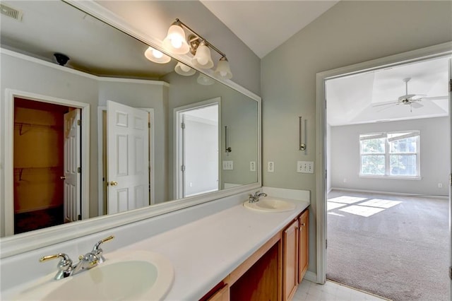 bathroom with ceiling fan, vaulted ceiling, double vanity, and tile patterned floors