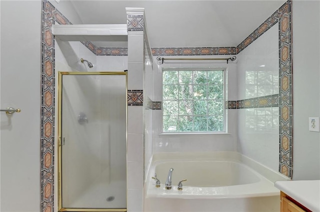 bathroom featuring independent shower and bath, vanity, and lofted ceiling