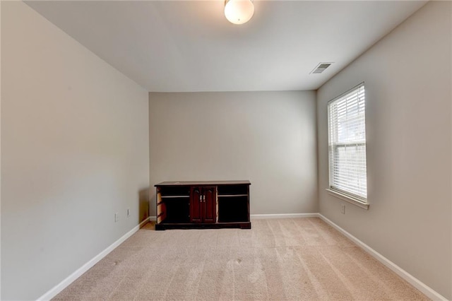 carpeted spare room with visible vents and baseboards