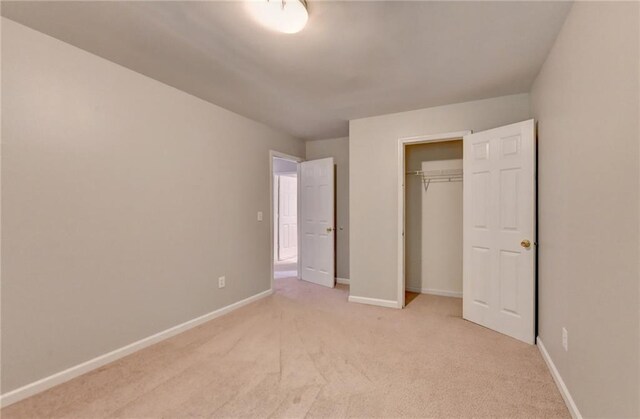 unfurnished bedroom featuring a closet and light carpet