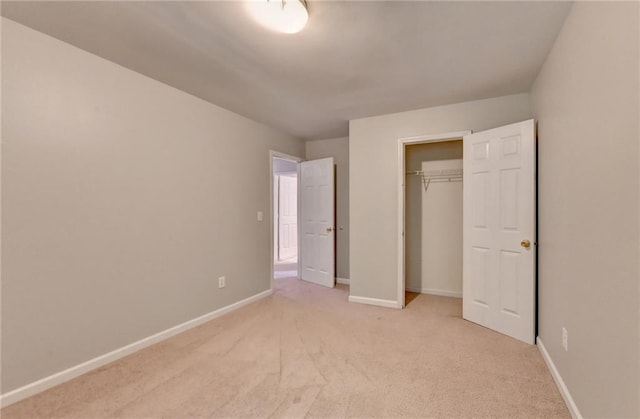 unfurnished bedroom featuring a closet, light colored carpet, and baseboards