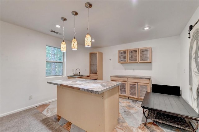 kitchen featuring light tile patterned floors, light brown cabinets, hanging light fixtures, and a kitchen island