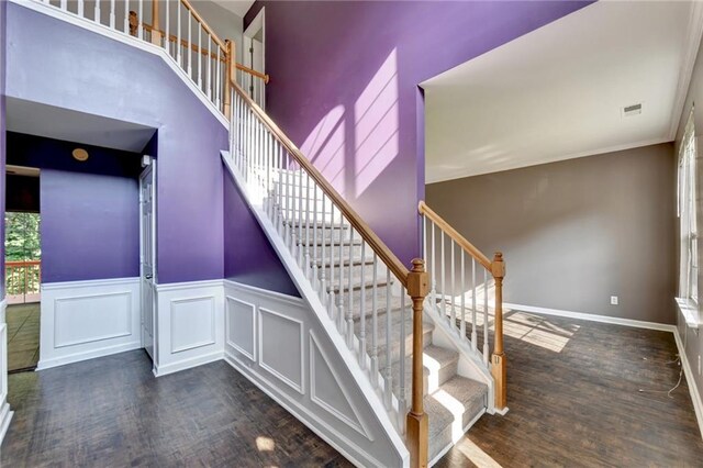 stairway with hardwood / wood-style flooring and crown molding