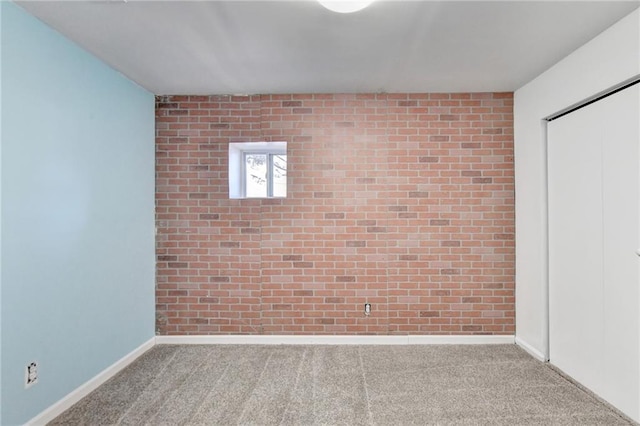 unfurnished room with carpet floors and brick wall