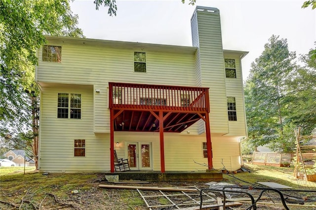 back of property featuring a deck, french doors, and a chimney