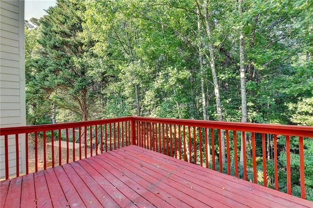 wooden terrace featuring a wooded view