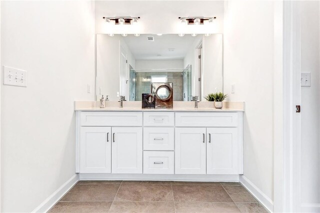 bathroom with tile patterned flooring, walk in shower, and vanity