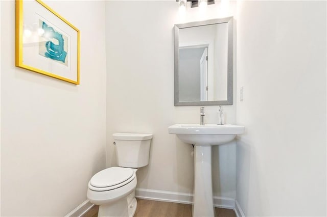 bathroom with hardwood / wood-style floors and toilet