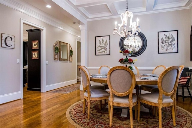 dining space with a chandelier, ornamental molding, wood finished floors, baseboards, and coffered ceiling
