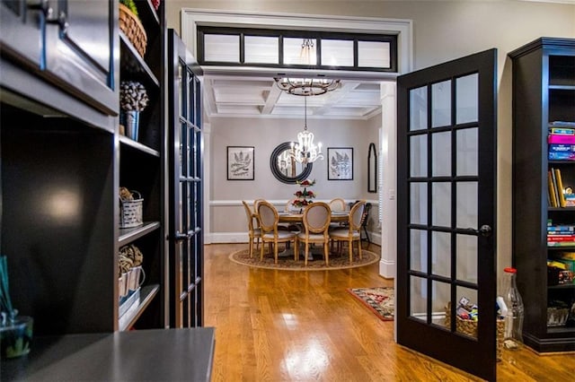 office area with french doors, coffered ceiling, a chandelier, ornamental molding, and wood finished floors