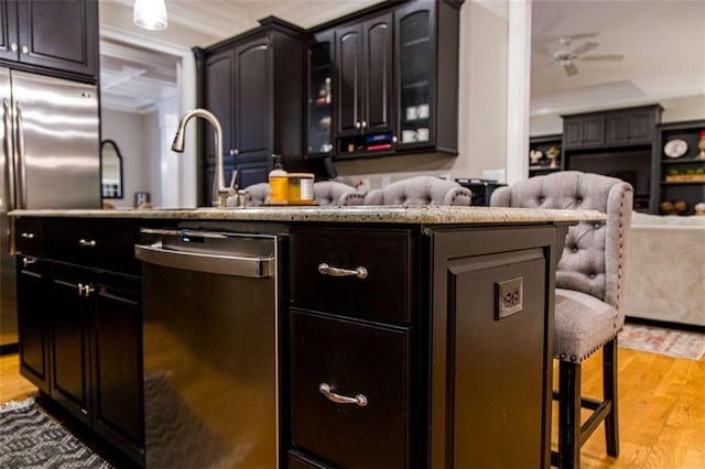 bar area with appliances with stainless steel finishes, light wood-type flooring, and a ceiling fan