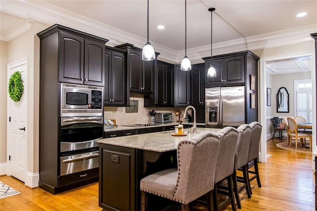 kitchen featuring a warming drawer, stainless steel appliances, light stone countertops, a kitchen breakfast bar, and tasteful backsplash
