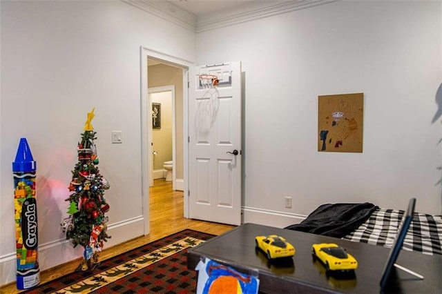 living room with wood finished floors, crown molding, and baseboards