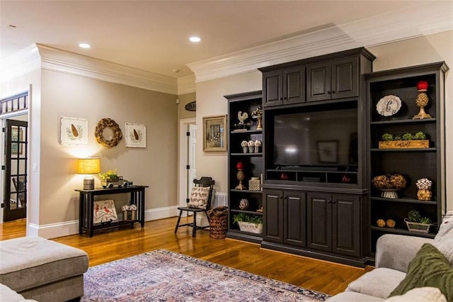 living area featuring wood finished floors, crown molding, baseboards, and recessed lighting