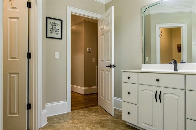 bathroom featuring baseboards, vanity, ornamental molding, and tile patterned flooring