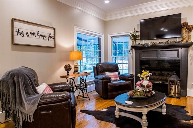 sitting room featuring wood finished floors, crown molding, a fireplace, and recessed lighting