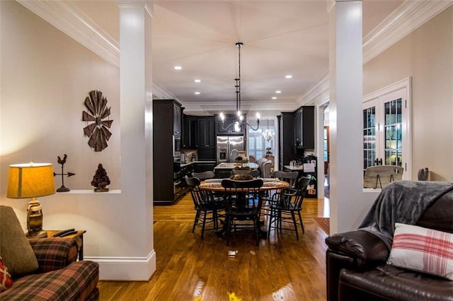 dining space with crown molding, wood finished floors, decorative columns, recessed lighting, and baseboards