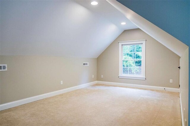 additional living space featuring light colored carpet, baseboards, recessed lighting, and vaulted ceiling