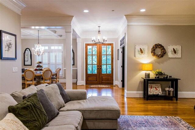 living room featuring a chandelier, crown molding, recessed lighting, french doors, and wood finished floors